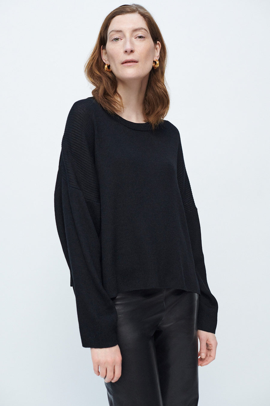 Model wearing AQVAROSSA Kenitra boxy sweater in black colour extra fine baby alpaca front view