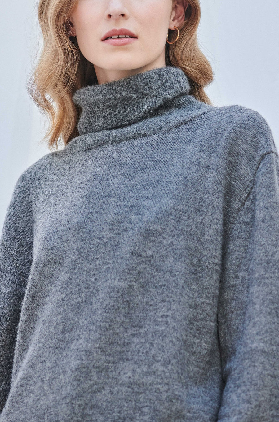 model wearing AQVAROSSA Juliaca wide knitted turtleneck in colour grey extra fine alpaca front close up view